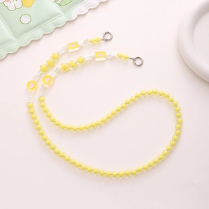 Detailed macro view of yellow acrylic beaded phone strap with cute heart and flower charms