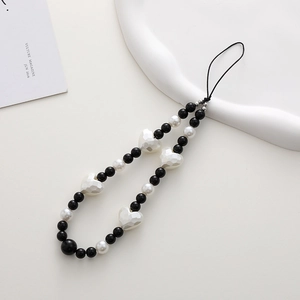 Detail view of black and white beaded phone strap with a large faceted heart pendant