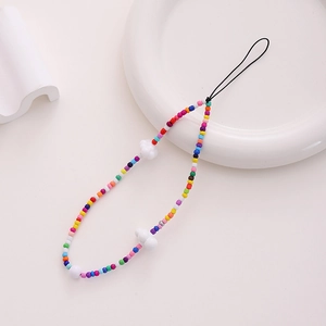 Colorful beaded phone wrist strap with white cloud charms on a minimalist white tray
