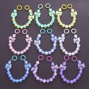 Luminous beaded phone strap with bow tie accents in nine colorful pastel resin styles