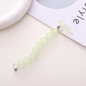 Detail of mint green frosted beads and translucent bear charm on a phone strap with silver clasps