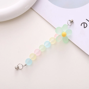 Detail of macaron matte beaded phone strap with flower charm and metal magnetic clasp