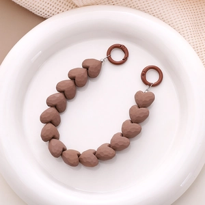 Detail of matte coffee heart-shaped beads on a lanyard with circular snap hooks