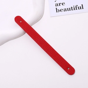 Detail of red lychee grain leather wrist strap with fine stitching and dual holes