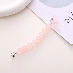 Detailed macro of pink matte beaded phone strap with a cute bear charm and silver clasp
