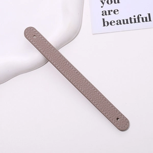 Detail view of grey lychee grain PU leather wrist strap with fine white stitching