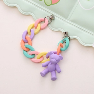 Close-up of matte colorful acrylic ring chain and purple 3D bear pendant jewelry