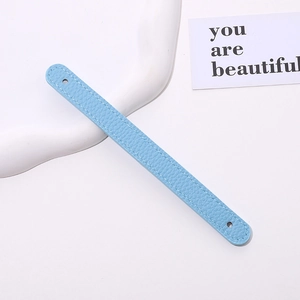 Detail view of light blue PU leather phone strap with white stitching and litchi texture