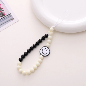 Detail of black and white acrylic beads phone strap featuring a cute smiley face charm