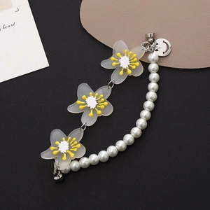 Close-up of floral pearl mobile chain with white matte flowers and smiley face charm