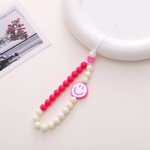 Detail of pink and cream acrylic beaded phone lanyard with smiley face and heart charms