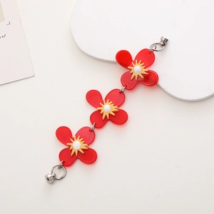 Detail of red acrylic flower charm chain with magnetic silver clasps and yellow accents