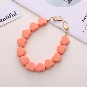 Dettaglio catena cuore arancione corallo con perle in silicone opaco e chiusure dorate
