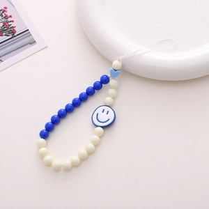 Detailed shot of blue and cream acrylic beaded phone strap with a smiling face and heart charm