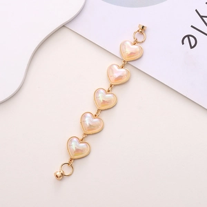 Close-up of heart-shaped iridescent charms with gold metal edges and magnetic clasps