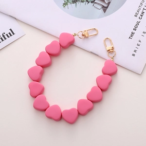 Dettaglio della catena di perle rosa opache a forma di cuore con fermagli dorati per cellulari