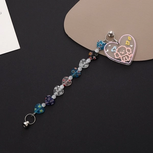 Detail showing colorful heart beads and transparent acrylic puppy pendant for phone chains