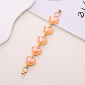Close-up of peach acrylic heart charm chain with gold magnetic clasp for phone cases