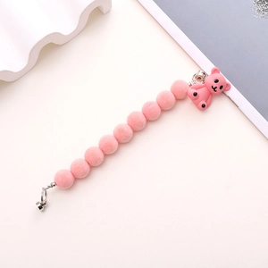 Detail of pink flocked beads and a resin bear pendant on a cute plush phone strap