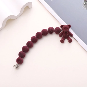 Detail of burgundy flocked bead phone strap with cute bear charm and silver metal rings