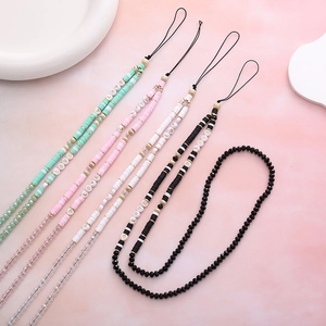 Handmade beaded phone charms with LOVE letters and colorful clay discs on pink marble