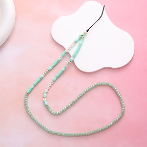 Macro detail of mint green beaded phone strap with LOVE acrylic letter beads