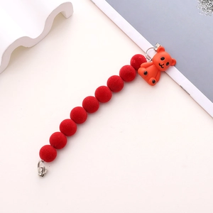 Detail of red plush bead phone chain with a cute orange bear charm and metal hooks
