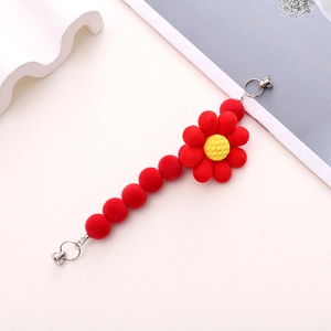 Detail of red floral plush magnetic curtain buckle with yellow core and silver magnet