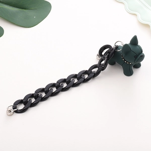 Close-up of matte dark green bulldog pendant and black acrylic chain for phone
