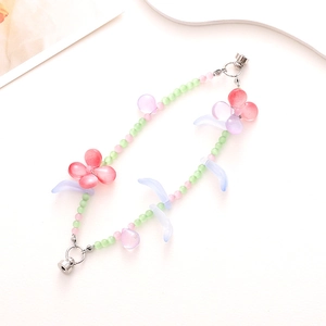 Detail of beaded butterfly phone charm with green beads and magnetic heart clasp