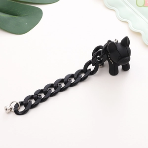 Detail of black resin French Bulldog charm with gold-studded collar and acrylic chain