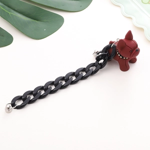 Detail view of a wine red resin bulldog pendant with a black acrylic chain and metal buckle
