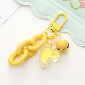 Detail of a bright yellow cartoon duck keychain with acrylic pendant and metal bell