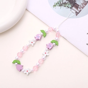 Detailed shot of handmade wooden flower beads and pink faceted charms on phone strap