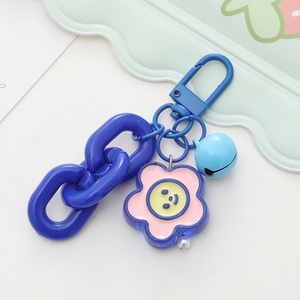Close-up of vibrant blue keychain with smiley flower charm and plastic chain links