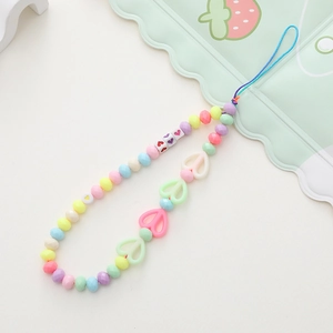 Detail of colorful beaded phone strap with acrylic heart and bear beads on white background