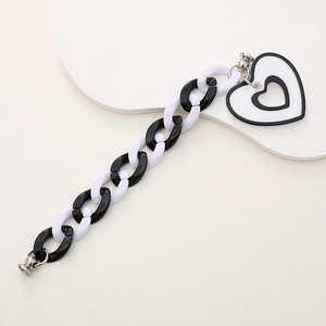 Detail of black and white acrylic chunky chain with a layered heart pendant charm