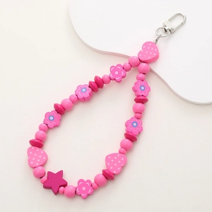 Detail of pink wooden fruit beads with heart and star charms on a metal clasp