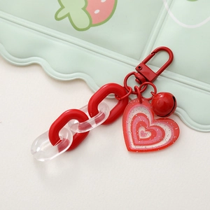 Dettaglio portachiavi a cuore rosso con catena in acrilico glitter e campanello