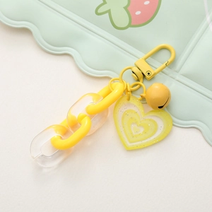 Dettaglio del ciondolo a cuore glitter giallo con campanello e portachiavi in acrilico