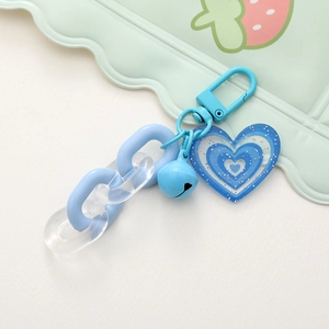 Dettaglio del portachiavi a cuore glitterato blu con campanellino e catena acrilica