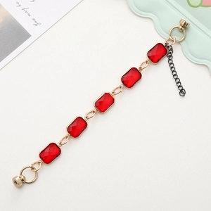 Detailed macro view of rectangular red crystal gems linked by a gold metal chain strap