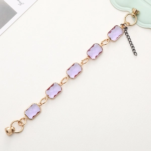 Golden bracelet featuring rectangular purple crystals and a secure magnetic clasp
