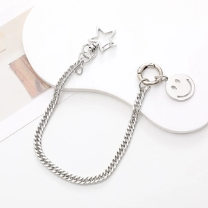 Close-up of silver metal chain with star clasp and hollow smiley face pendant charm