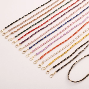 Détail de la chaîne en métal tressé avec lanières en cuir coloré et fermoirs dorés