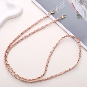 Détail de la chaîne dorée entrelacée de cuir rose avec mousquetons pour sacs à main