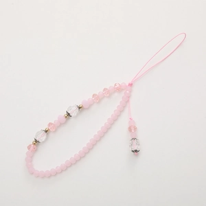 Pink beaded phone charm with crystal butterfly and matte beads on a white background