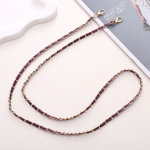 Détail d'une chaîne en métal doré tissé de cuir violet avec fermoirs mousquetons doubles
