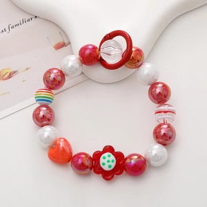 Detail of colorful beaded phone strap with red hearts and floral charms on a white stand