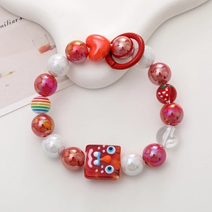 Close-up of colorful beaded phone strap with red heart and strawberry charms